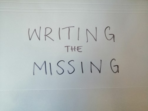 photo description: My grey folder. Written on it in capital letters in black sharpie is WRITING THE MISSING